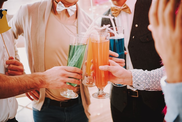 Gay clink glasses at gay parties with different cocktails.