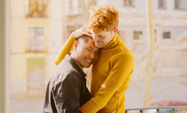 Photo gay couple embracing on the balcony at home