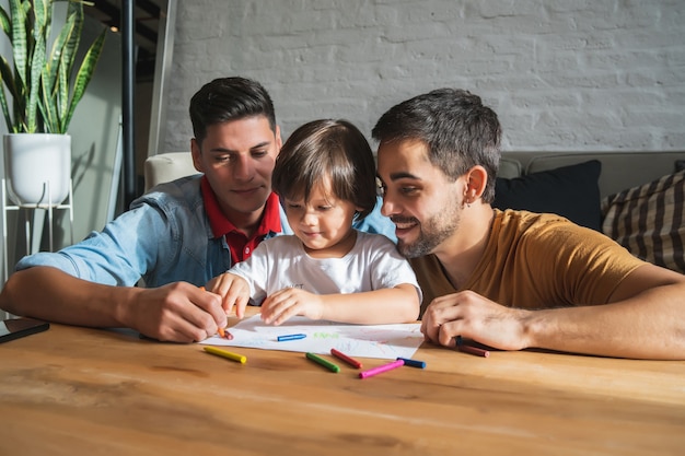 Gay couple having fun with their son at home.