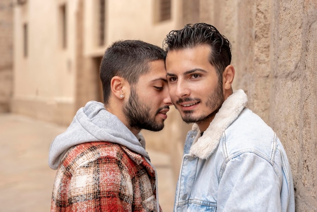 Gay couple in love on the street one of them looking the other way