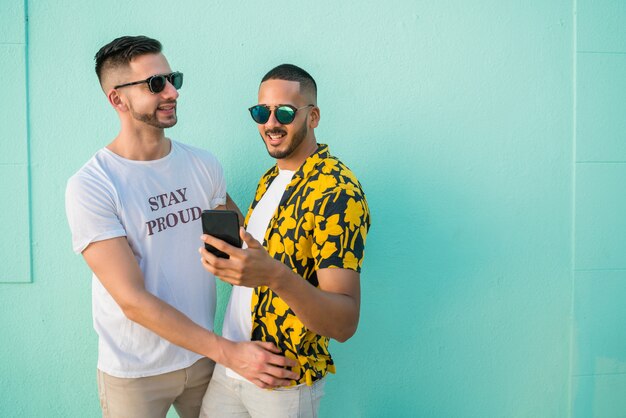 Gay couple spending time together while using phone.