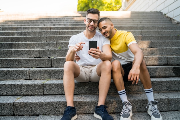Gay couple spending time together while using phone.