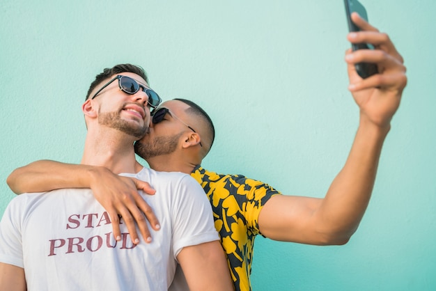 Gay couple taking a selfie with mobile phone.