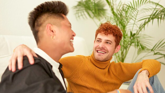 Photo gay couple talking and smiling on the sofa