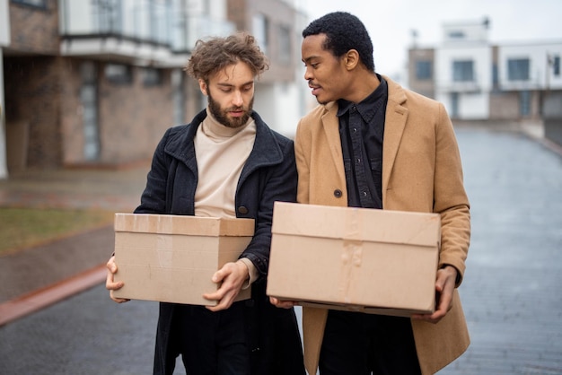 Gay couple walking together with parcels outdoors