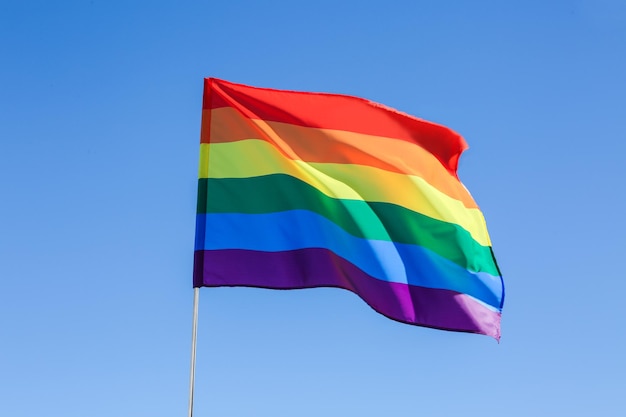 Gay flag on blue sky background