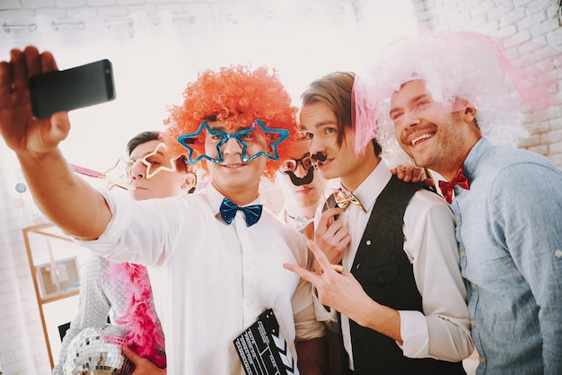 Gay guys are taking selfie on phone at party