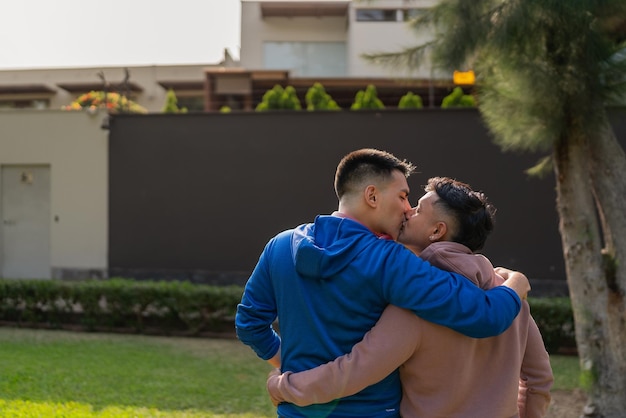 Gay male couple kissing in front of a house in a residential area