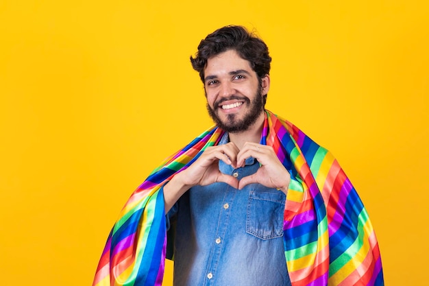 Gay man smiling looking at the camera making a heart with his hand