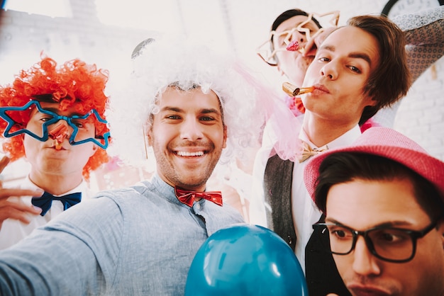 Foto i gay in papillon prendendo selfie al telefono alla festa.