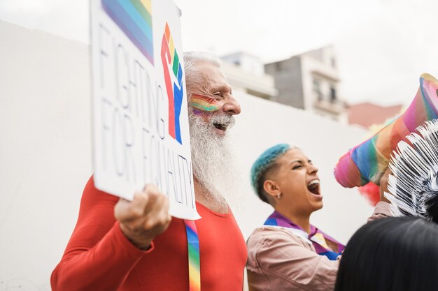 동성애자들은 야외 lgbt 프라이드 행사에서 항의합니다 - 힙스터 시니어 남자 얼굴에 초점