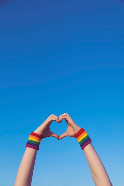 Foto gay pride-concept hand die een hartteken maakt met gay pride lgbt-regenboogvlag-polsbandje