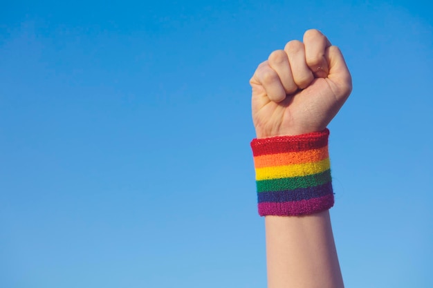 Gay Pride-concept Hand die een vuistteken maakt met Gay Pride LGBT-regenboogvlagpolsband