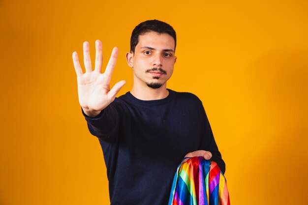 Gay Pride. Homoseksuele jongen met zijn hand naar voren die een stopteken maakt tegen vooroordelen