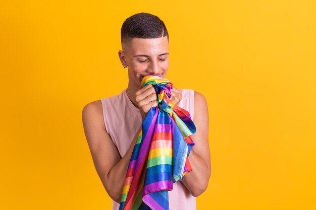 Gay pride Homosexual boy kissing lgbt flag on yellow background