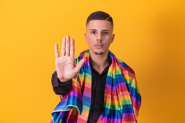 Foto gay pride ragazzo omosessuale con la mano in avanti facendo un segnale di stop al pregiudizio