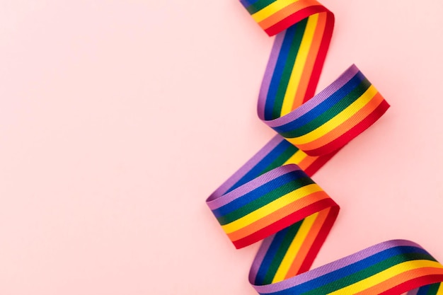 Gay pride LGBT rainbow ribbon on pink background