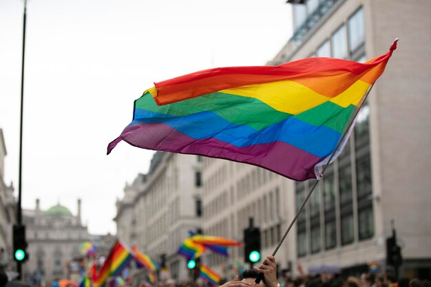 Gay pride lgbtq rainbow flags being waved in the air at a pride event