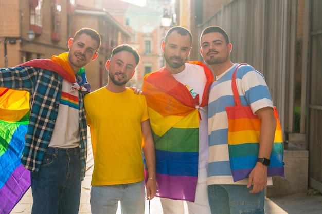 Gay pride party in the city portrait of couples of men in the demonstration with the rainbow flags Concept of lgbt