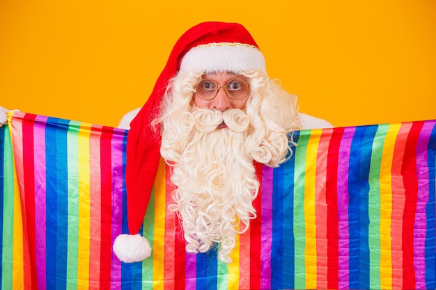 Гей Санта-Клаус держит флаг ЛГБТ. Рождество гей-прайд концепции.