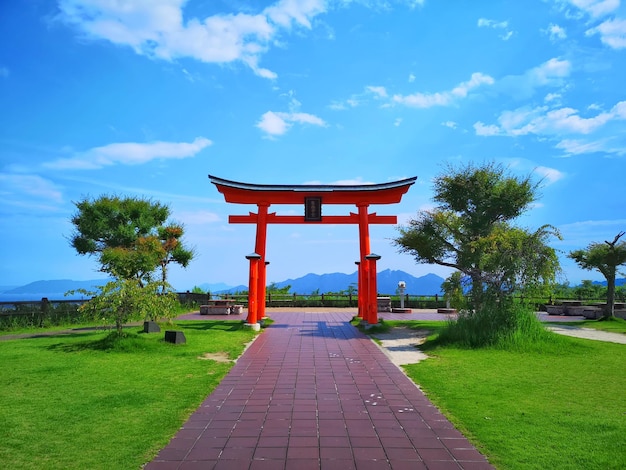 Gazebo on footpath against cloudy sky