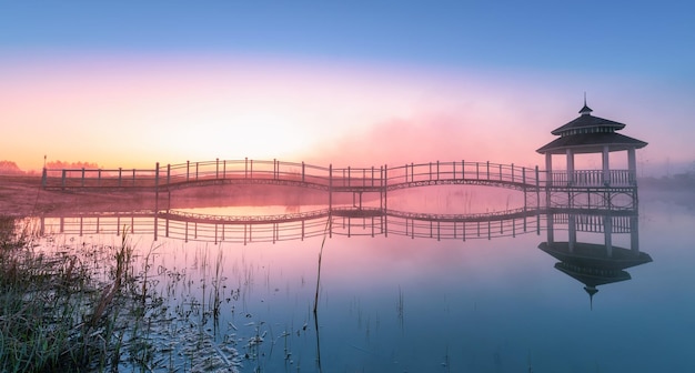 Gazebo on the lake Morning fog and dawn or sunset