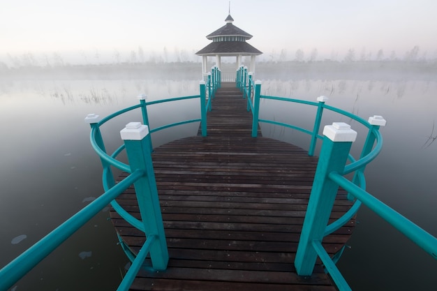 Gazebo op het meer Ochtendmist en zonsopgang of zonsondergang