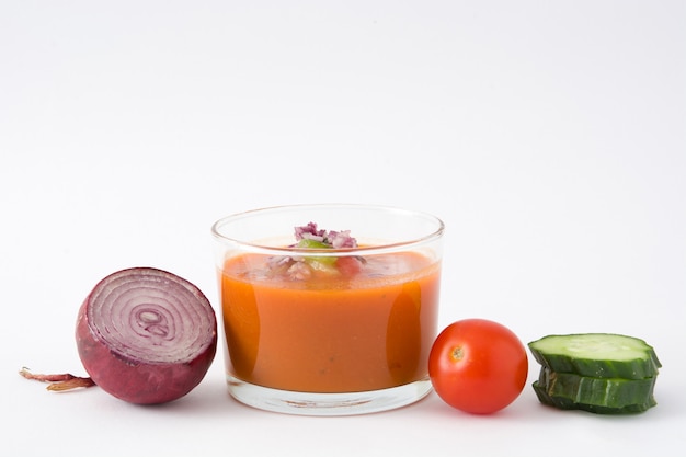 Gazpacho soup in glass isolated on white table