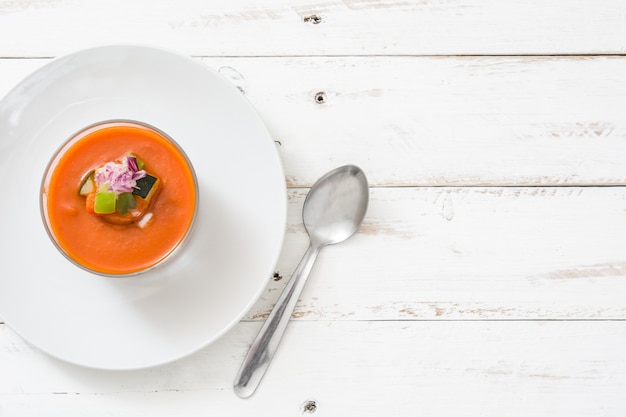 Gazpacho soup in glass on white wooden