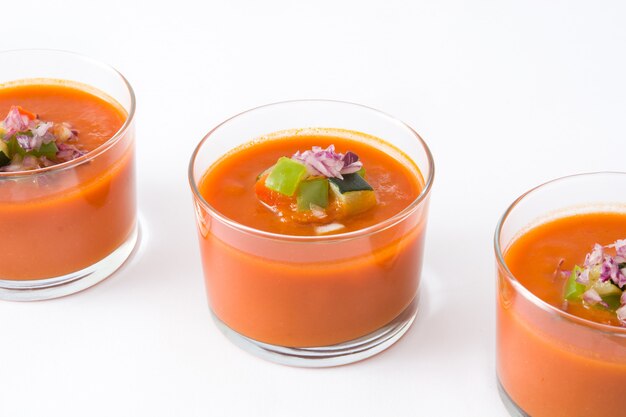 Gazpacho soup in glass on white