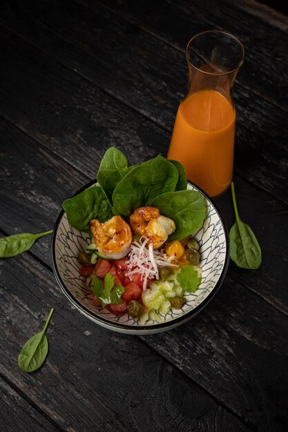 Gazpacho with spinach and vegetables on a wooden table