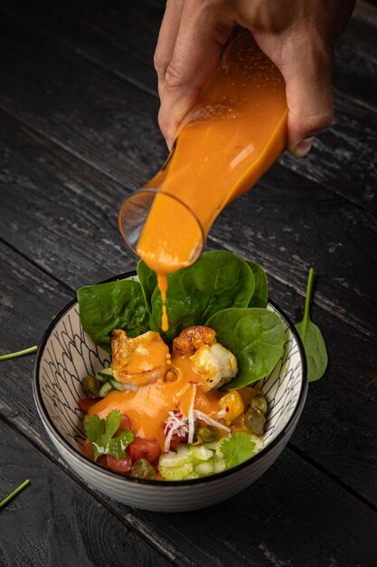 Gazpacho with spinach and vegetables on a wooden table