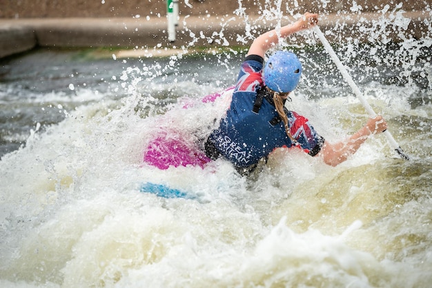 Foto gb canoe slalom atleet in de c1w klasse in wit water actie peddelen weg omringd door spetteringen