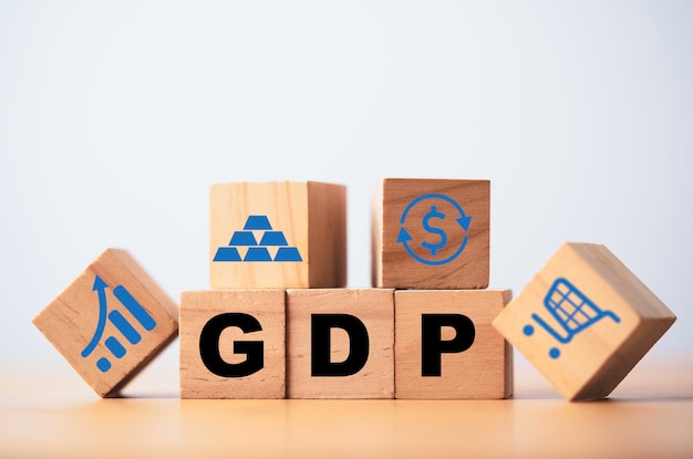 GDP または国内総生産の言葉遣いの印刷画面を木製の立方体ブロックにアイコン付きで表示するには、経済不況の概念のためのグラフのドル交換ショッピング トロリーと金の延べ棒が含まれます