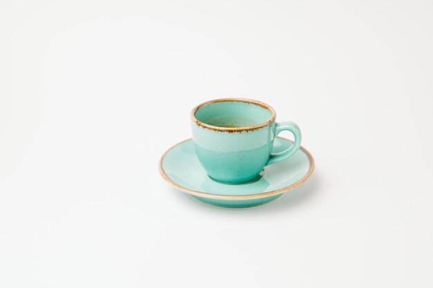 GeÃ¯soleerd op wit shot van een turquoise kop en schotel met een beetje espresso