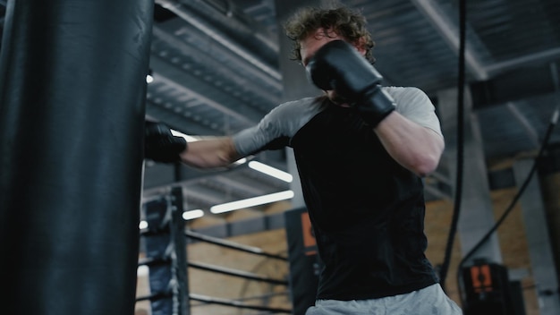 Geagiteerde vechter bezig met klappen in fitnesscentrum Sportman trainingsschoppen