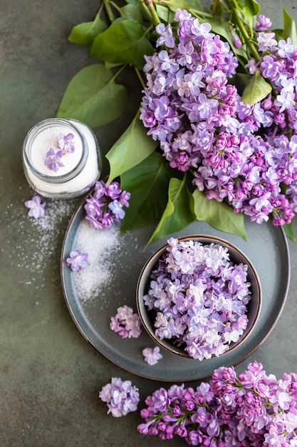 Gearomatiseerde suiker met lila bloemen en tak van lila Eetbare bloemen in de keuken en zoetwaren