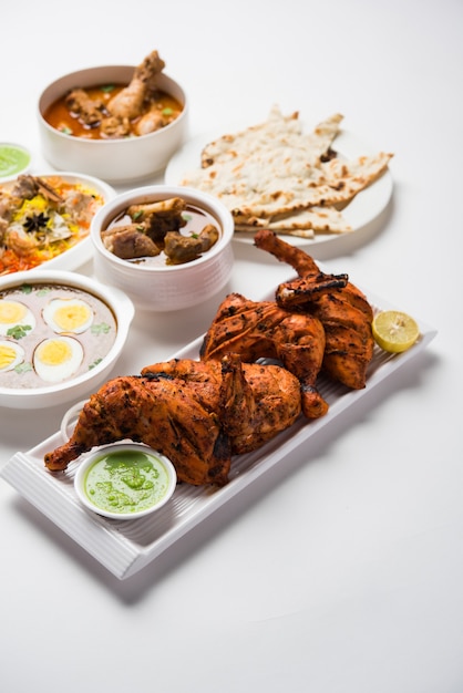 Geassorteerd Indiaas niet-vegetarisch voedselrecept geserveerd in een groep. Inclusief Chicken Curry, Mutton Masala, Anda of egg curry, Butter chicken, biryani, tandoori murg, chicken-tikka en naa, roti voor ramadan