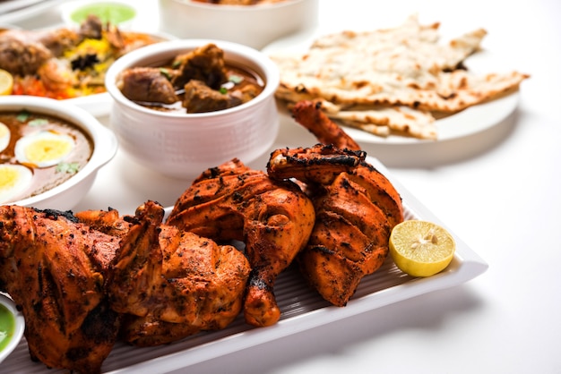 Geassorteerd Indiaas niet-vegetarisch voedselrecept geserveerd in een groep. Inclusief Chicken Curry, Mutton Masala, Anda of egg curry, Butter chicken, biryani, tandoori murg, chicken-tikka en naa, roti voor ramadan