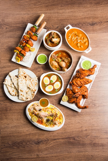 Geassorteerd Indiaas niet-vegetarisch voedselrecept geserveerd in een groep. Inclusief Chicken Curry, Mutton Masala, Anda of egg curry, Butter chicken, biryani, tandoori murg, chicken-tikka en naa, roti voor ramadan