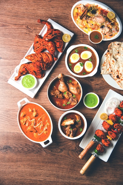 Geassorteerd Indiaas niet-vegetarisch voedselrecept geserveerd in een groep. Inclusief Chicken Curry, Mutton Masala, Anda of egg curry, Butter chicken, biryani, tandoori murg, chicken-tikka en naa, roti voor ramadan