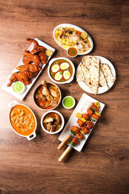 Geassorteerd Indiaas niet-vegetarisch voedselrecept geserveerd in een groep. Inclusief Chicken Curry, Mutton Masala, Anda of egg curry, Butter chicken, biryani, tandoori murg, chicken-tikka en naa, roti voor ramadan