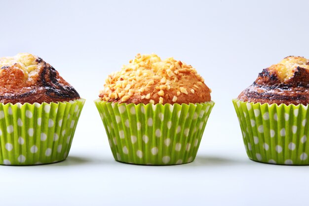 Foto geassorteerd met heerlijke eigengemaakte cupcakes met rozijnen en chocolade die op witte achtergrond wordt geïsoleerd. muffins.