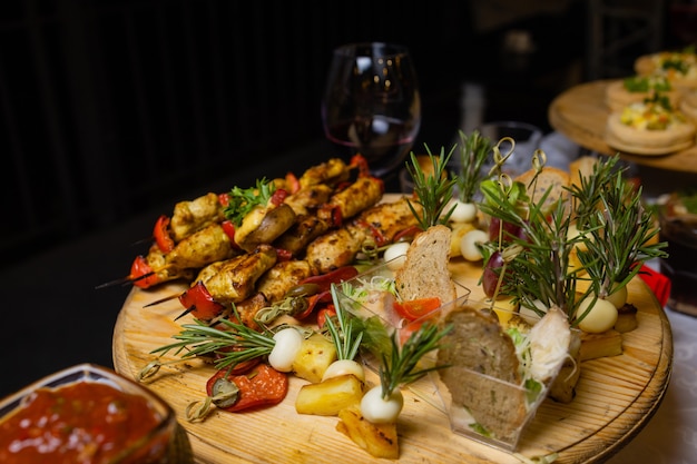 Geassorteerd vlees op een plaat close-up. Verschillende soorten vlees en aardappelen in een hoop. Voorgerecht op een groot bord met sauzen.