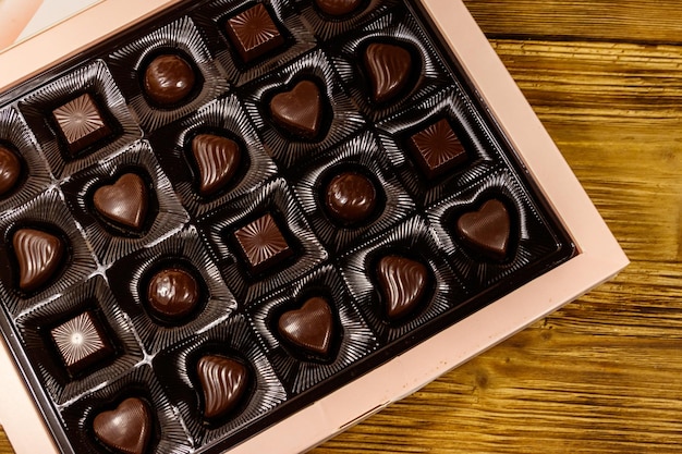 Geassorteerde chocolade snoepjes in een doos op houten tafel bovenaanzicht