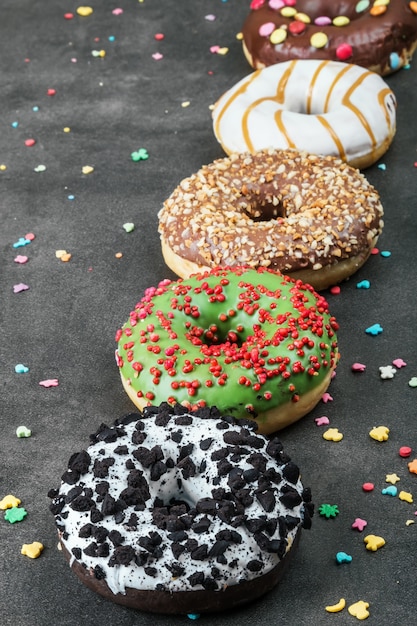 Geassorteerde donuts met suikerglazuur en gevoelens op een zwarte achtergrond