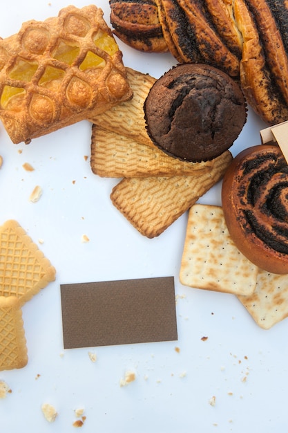 Foto geassorteerde gebakjes met wit leeg visitekaartje