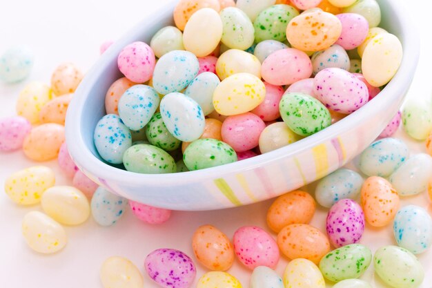 Geassorteerde jelly beans in pastelkleuren met donkere vlekken.