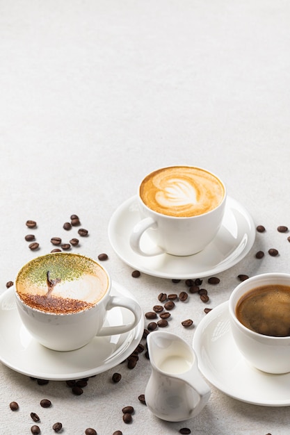 Geassorteerde kopjes koffie op de witte achtergrond