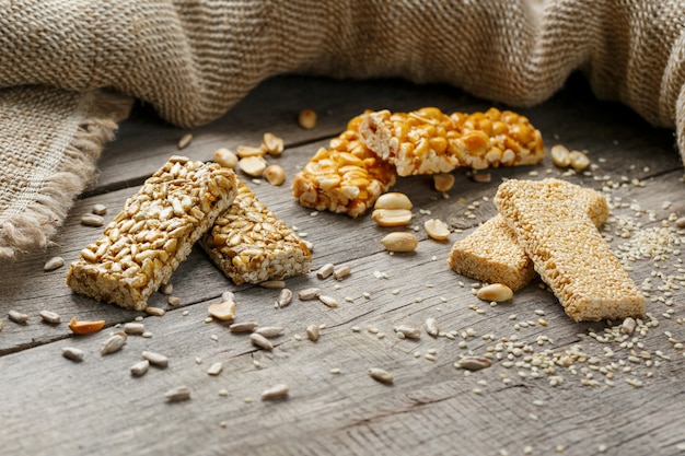 Geassorteerde kozinaki ,, met jute stof. Landelijke stijl. Heerlijke zoetigheden van de zaden van zonnebloem, sesam en pinda's, bedekt met glanzend glazuur.